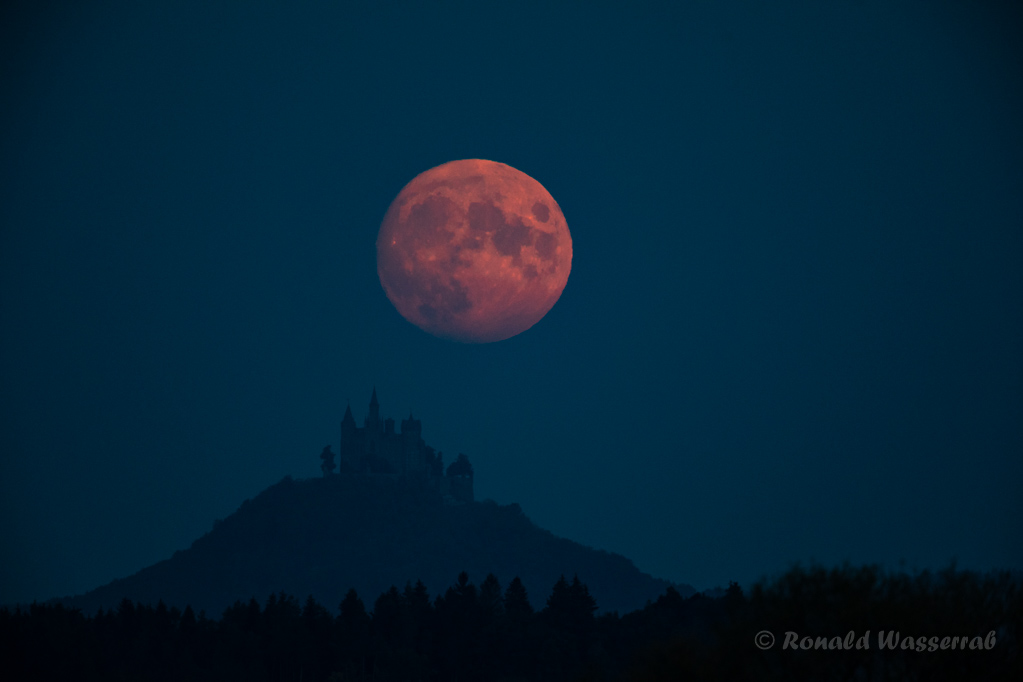 Der Mond schwebt über der Burg